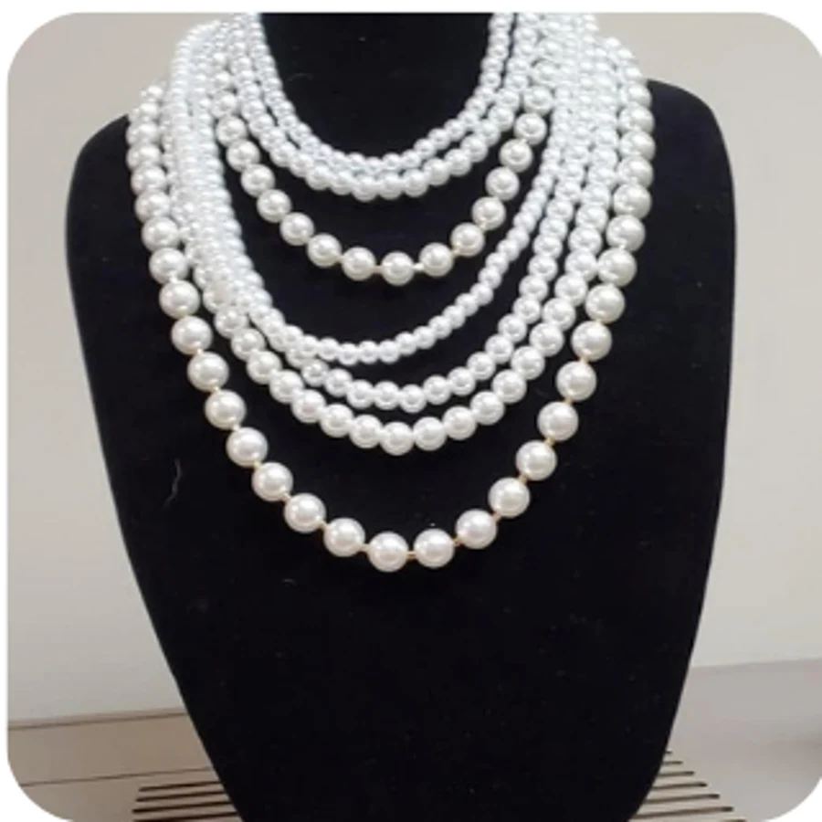 Multi-strand cascading pearl statement necklace on a display bust