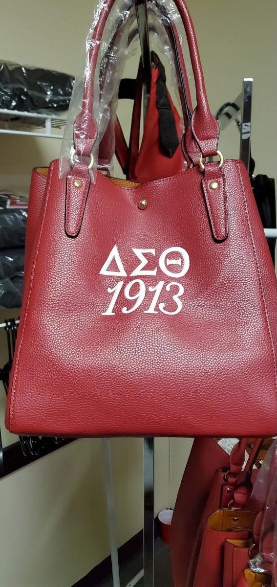 Crimson pebbled tote with white Delta Sigma Theta 1913 lettering and gold hardware