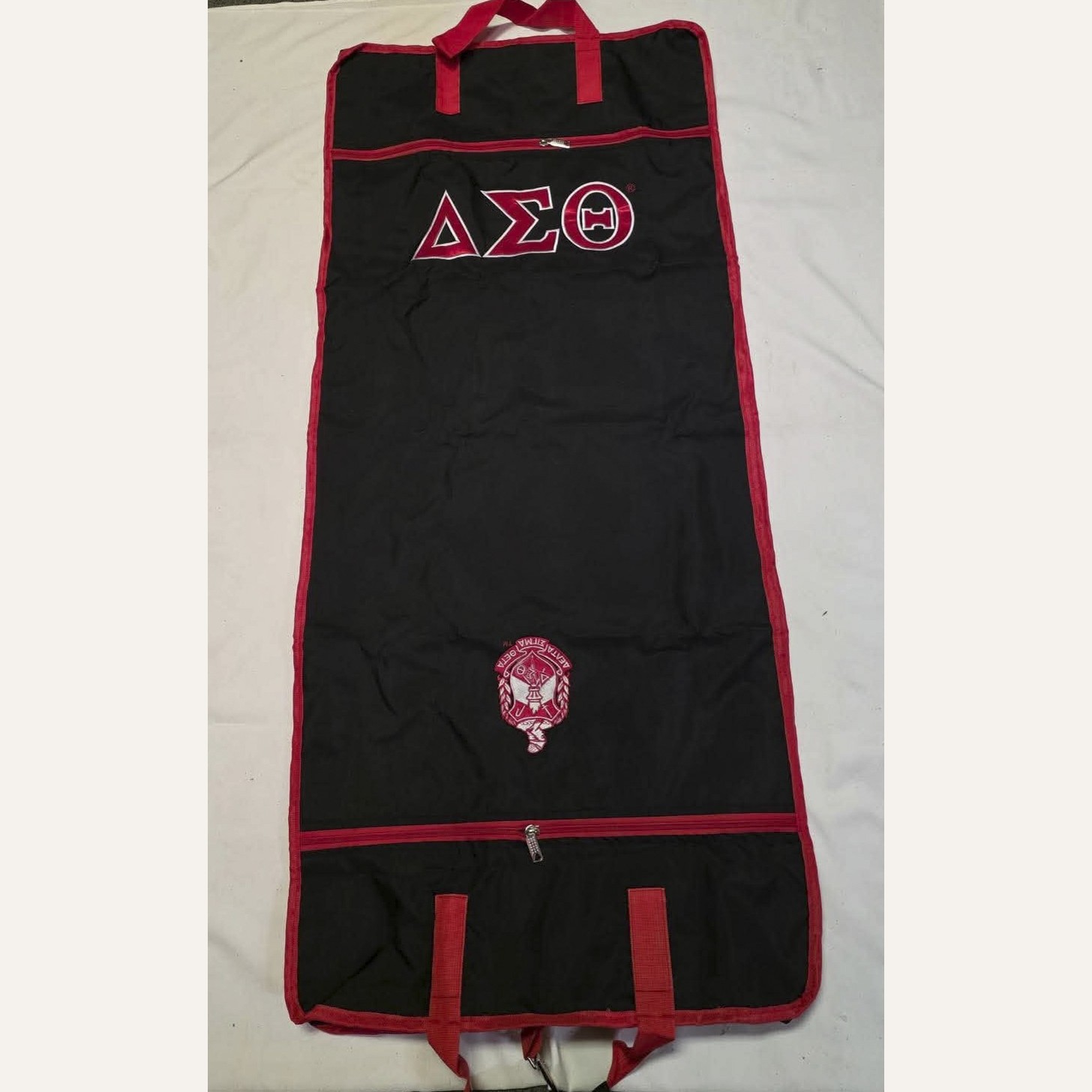 Black Delta Sigma Theta garment bag with crimson trim and embroidered crest