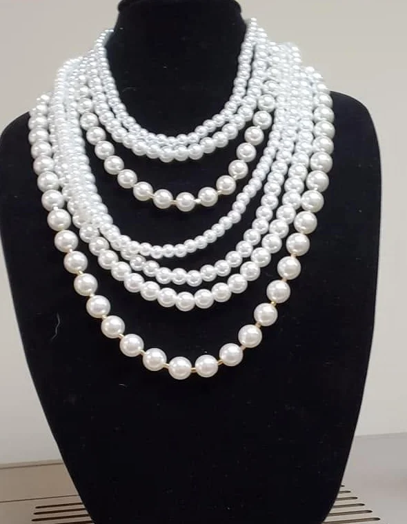 Multi-strand white pearl statement necklace on a black display bust