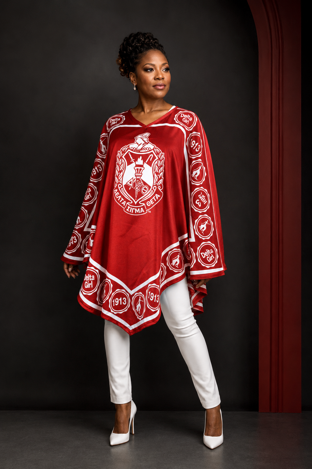 Delta woman in crimson Delta Girl crest poncho with white trousers