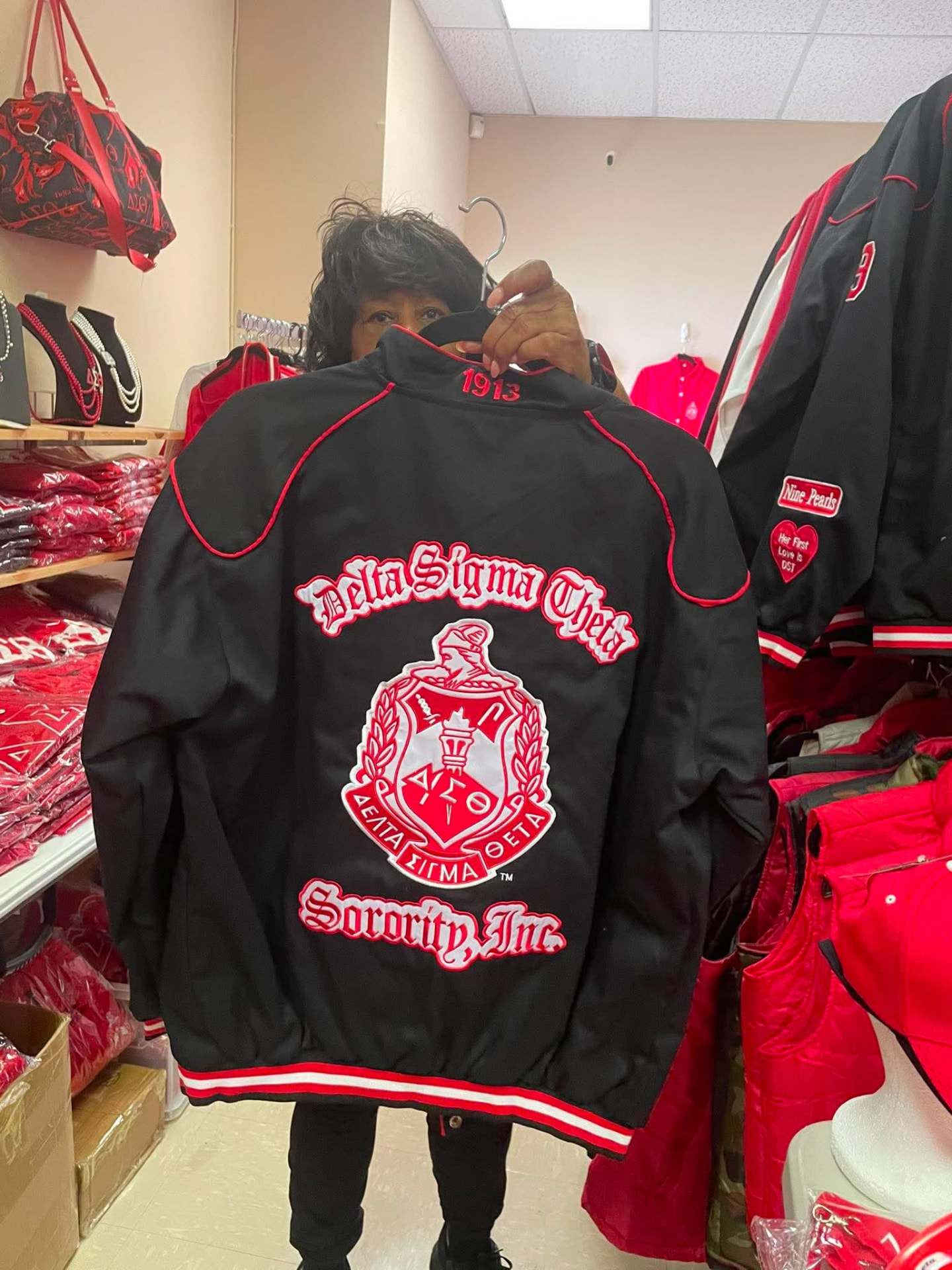 Back of the black Delta Racer Jacket showing the embroidered Delta Sigma Theta Sorority, Inc. crest
