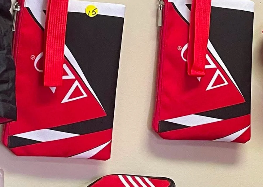 Red, white and black Delta Sigma Theta wristlet pouches with geometric stripe design and red wrist straps