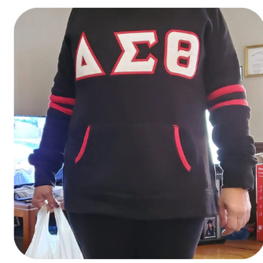 Black tunic-length pullover with white DST letters and red sleeve stripes