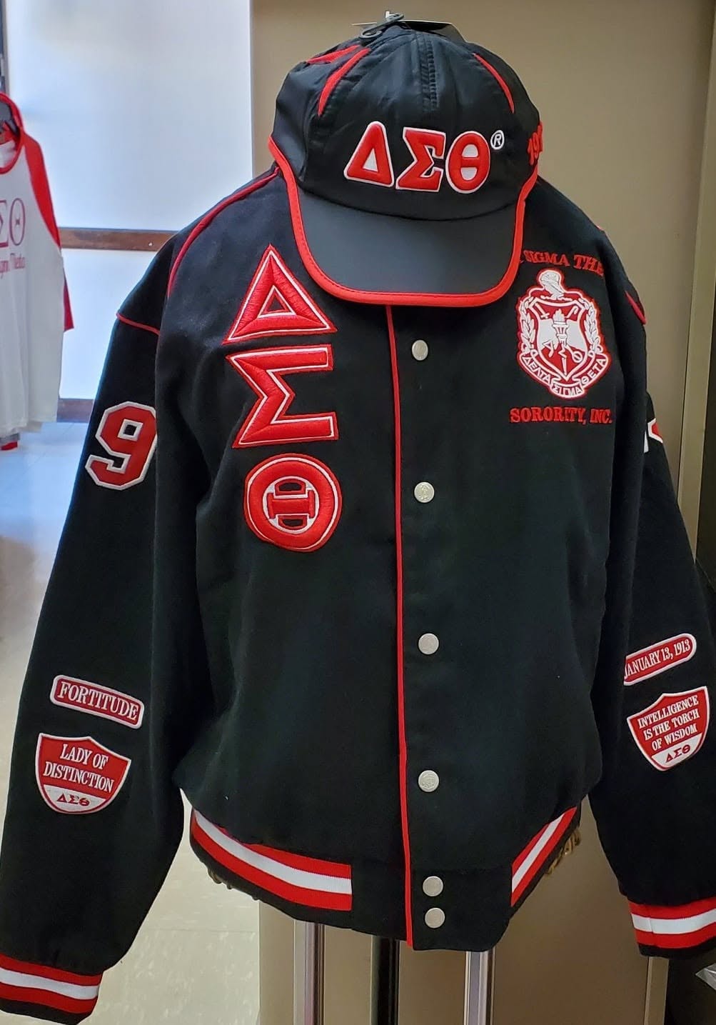 Black Delta Racer Jacket with red ΔΣΘ letters, embroidered Sorority crest, and commemorative patches